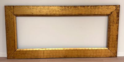 an old picture frame sitting on a wooden floor next to a wall