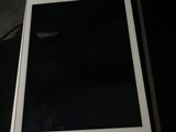 Un iPad est posé sur une boîte, sur une table.