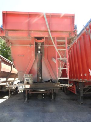 un camion-benne rouge garé à côté d'un autre camion-benne rouge