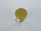 l'image d'une bague en or sur laquelle se trouve une pièce de monnaie