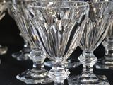 six clear glass goblets sitting on top of a black table