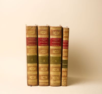 trois vieux livres posés l'un sur l'autre sur une surface blanche