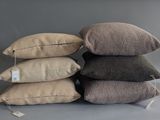 several pillows are stacked on top of each other on a table