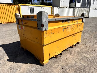 une benne jaune posée dans la terre