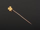 a gold flower on a stick against a black background