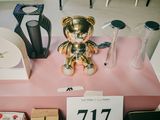 un ours en peluche doré posé sur une table rose