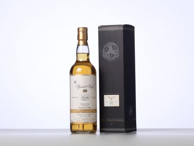 une bouteille de whisky posée sur une table à côté d'un coffret