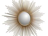 un miroir doré à rayons de soleil sur un mur blanc, avec un fond blanc