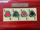 une boîte en bois sur laquelle sont représentées quatre cartes à jouer