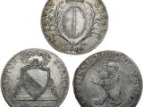 trois pièces d'argent sur lesquelles figurent des armoiries et un bouclier