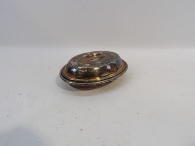 un petit objet argenté sur une surface blanche
