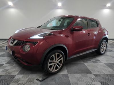 the red nissan juke suv is parked in the garage