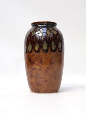 a brown vase that is sitting on a white surface