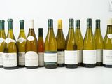 plusieurs bouteilles de vin sont alignées sur une surface blanche