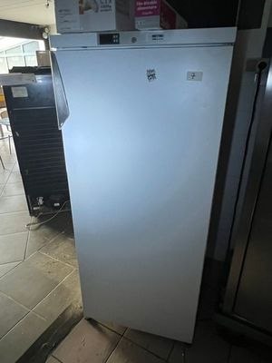 un réfrigérateur blanc posé au milieu d'une pièce