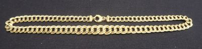 a close up of a gold chain on a black surface
