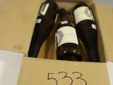 three bottles of wine in a cardboard box on a table