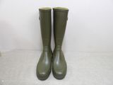 green rubber boots are lined up against a white wall