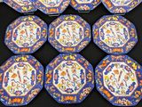 six blue and orange plates with designs on them sitting on a table
