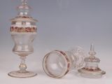 trois vases en verre et un bougeoir en verre sur une surface blanche