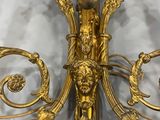 a gold colored wall sconce with a bird on it
