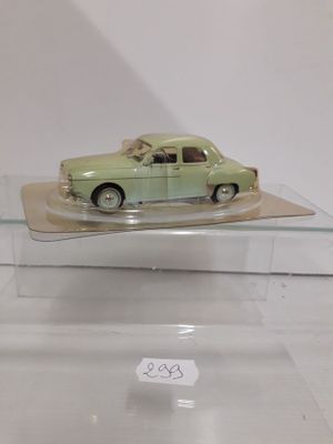 a green toy car on display in a glass case