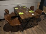 une table en bois avec quatre chaises et un verre de vin posé dessus