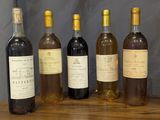 several bottles of wine are lined up on a wooden table