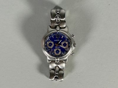 a silver watch with a blue face on a white surface