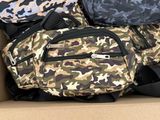 three bags in a cardboard box one is camouflage and the other is black and white