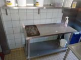 a kitchen with a sink, stove, and shelves in it