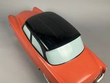 an orange toy car sitting on top of a white surface