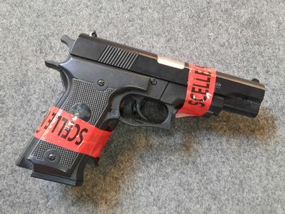 a gun with a red tape around it on the floor