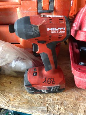 une perceuse rouge et un casque rouge posés sur une table