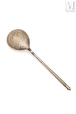 une cuillère ancienne avec un manche en métal sur fond blanc