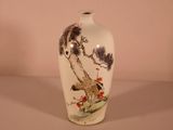 a white vase with a painting on it on a table