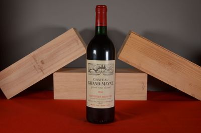 une bouteille de vin posée sur une table à côté d'une caisse en bois