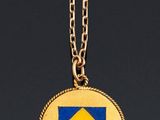 a close up of a gold coin with a blue and yellow diamond on it