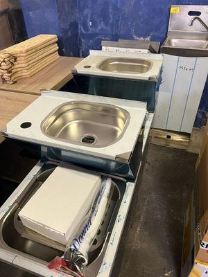 un évier et une machine à laver dans une pièce en cours de rénovation