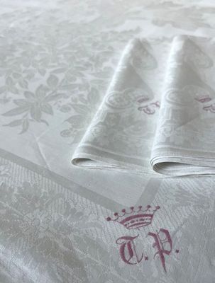 deux serviettes pliées sur un lit orné d'une couronne