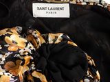 a close up of a black and yellow dress with flowers on it
