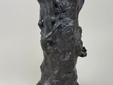 a sculpture of a tree trunk with a bird perched on it