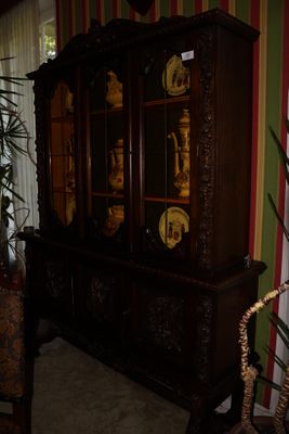 un vaisselier en bois dans un salon, avec une plante en pot