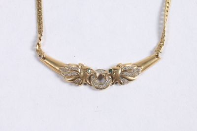 a close up of a gold necklace with diamonds on a white background