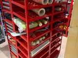 de nombreuses bobines de fil posées sur un présentoir rouge dans un magasin
