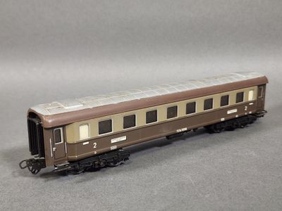 un wagon marron et blanc posé sur une surface grise