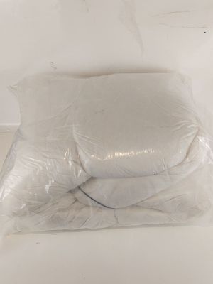 two pillows that are wrapped in plastic on the floor