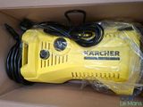 yellow karcher pressurer in a cardboard box with a black cord