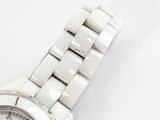 a close up of a white watch on a white surface