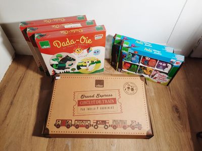 trois cartons de livres pour enfants posés par terre